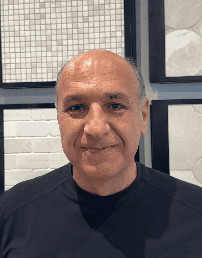 Man smiling in front of bathroom tile display at Hamilton Bath.